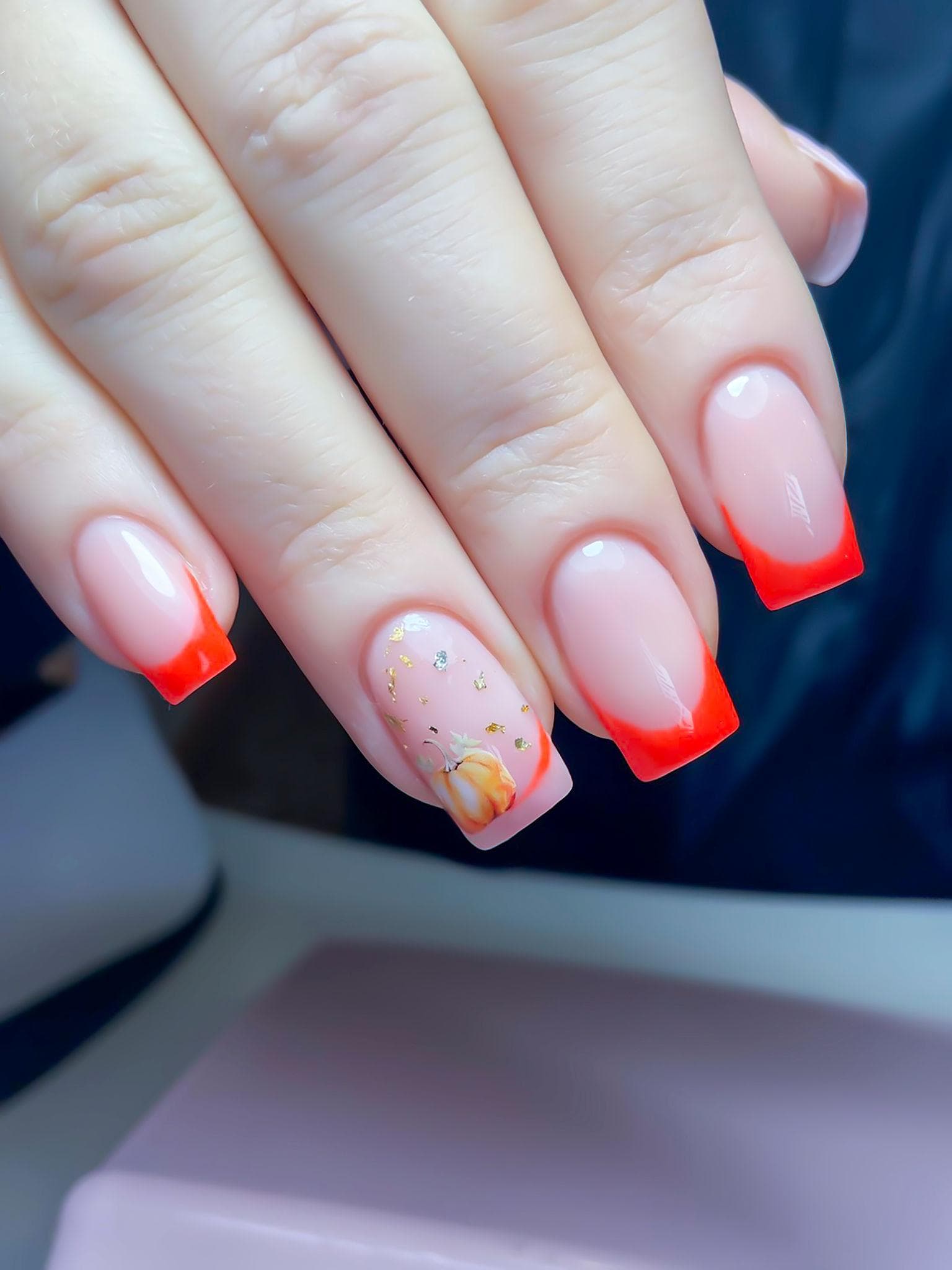 Close-up of red French tip nail art with a soft pink base